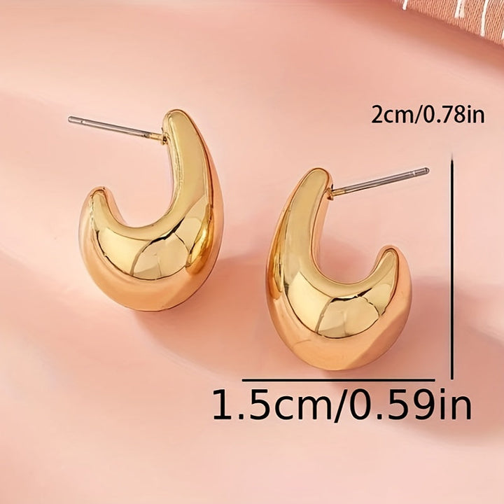 Minimalistické zlaté náušnice ve skulpturální C-Formě